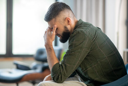 Depressed man sitting near window