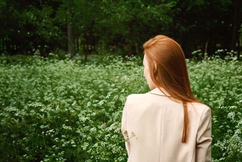 Woman walking through peaceful meadow